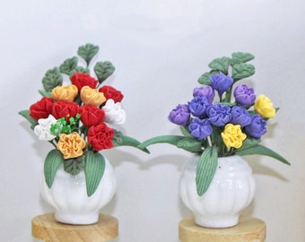 Puede incluir: Dos arreglos florales en miniatura en macetas de cerámica blanca sobre taburetes de madera. Las flores están hechas de tela e incluyen flores rojas, naranjas, blancas, moradas y amarillas.