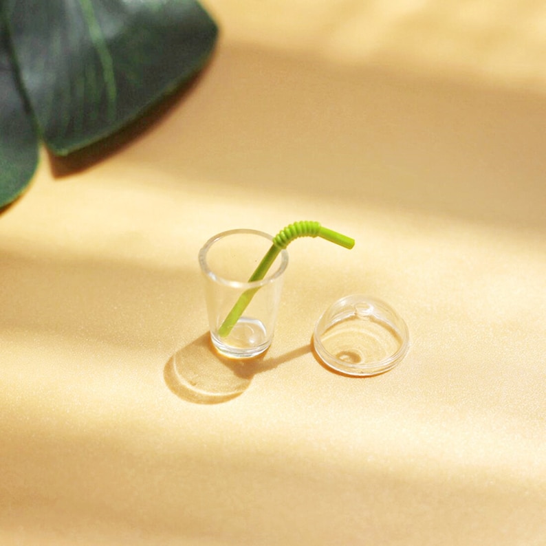 Puede incluir: Un vaso de pl&aacute;stico transparente con una pajita verde y una tapa de pl&aacute;stico transparente a juego. El vaso y la tapa son para la decoraci&oacute;n de una casa de mu&ntilde;ecas en miniatura.