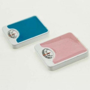 Peut inclure: Deux balances de salle de bain miniatures, l'une bleue et l'autre rose, avec des bases blanches et des cadrans noirs. Les balances sont conçues pour les maisons de poupées ou les décors miniatures.