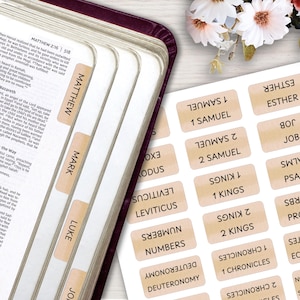 May include: A set of adhesive Bible index tabs with a beige watercolor design and black text. The tabs feature names of books such as Matthew, Mark, Luke, 1 Samuel, 2 Samuel, 1 Kings, 2 Kings, 1 Chronicles, 2 Chronicles, Leviticus, Numbers, and Deuteronomy.
