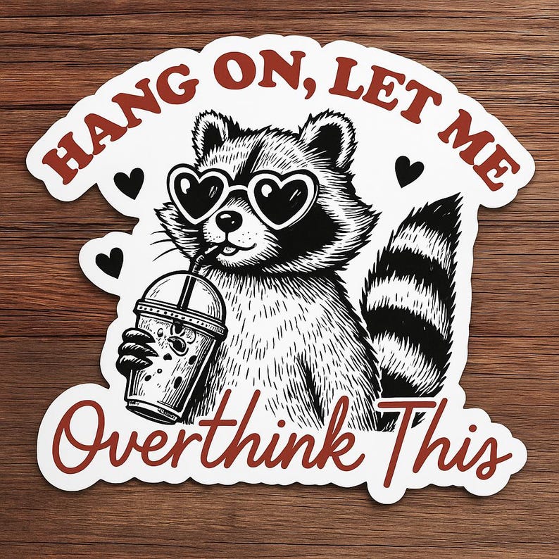 May include: A black and white sticker featuring a raccoon wearing heart-shaped sunglasses and drinking from a beverage cup. The sticker has the text "HANG ON, LET ME Overthink This" in a red, stylized font, with black heart accents.