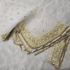 May include: White sheer scarf with gold embroidered trim and sequins. The scarf has a delicate, feminine look.