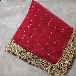 May include: A red sheer veil with gold sequins and a gold beaded border.