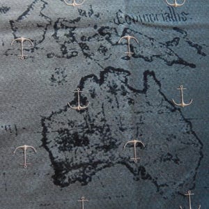 May include: A nautical-themed fabric with a map design and scattered anchor motifs. The map is in dark blue and gray tones, with the word "Equinoctials" visible. The anchors are in a light gold color.