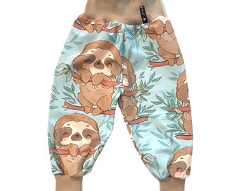 May include: Light blue baby pants with a sloth print. The sloths are brown and have a cute expression. The pants have a brown elastic waistband and cuffs.