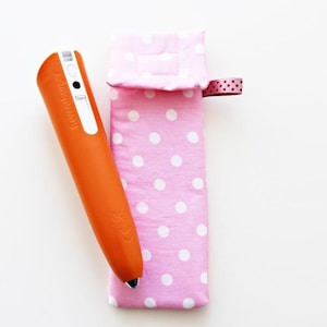 May include: An orange pen with a white label that says "TOUCH & DRAW" is in a pink polka dot fabric case with a pink ribbon.