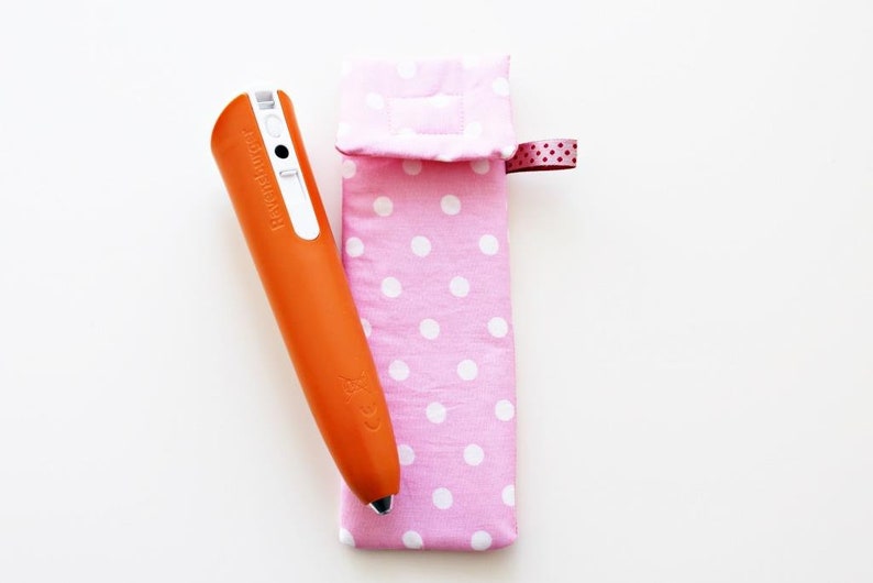 May include: An orange pen with a white label that says "TOUCH & DRAW" is in a pink polka dot fabric case with a pink ribbon.