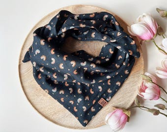 Puede incluir: Un pañuelo negro con un patrón de arcoíris y pequeños puntos blancos. El pañuelo tiene una etiqueta marrón con el texto "Made With Love" en él.