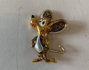 May include: A gold-tone mouse brooch with black and white details. The mouse is standing on its hind legs with its tail curled up. The mouse has a red nose and black eyes.