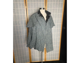 Puede incluir: Una capa de tweed azul y gris con cuello de piel sintética negra y cierre de botón.
