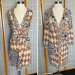 May include: Two sleeveless dresses with a geometric pattern in shades of brown, white, and blue. The dresses have a V-neckline and a loose fit.