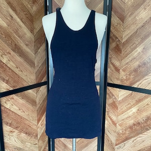 May include: A navy blue sleeveless tank top on a white mannequin. The tank top is made of a soft, stretchy fabric.
