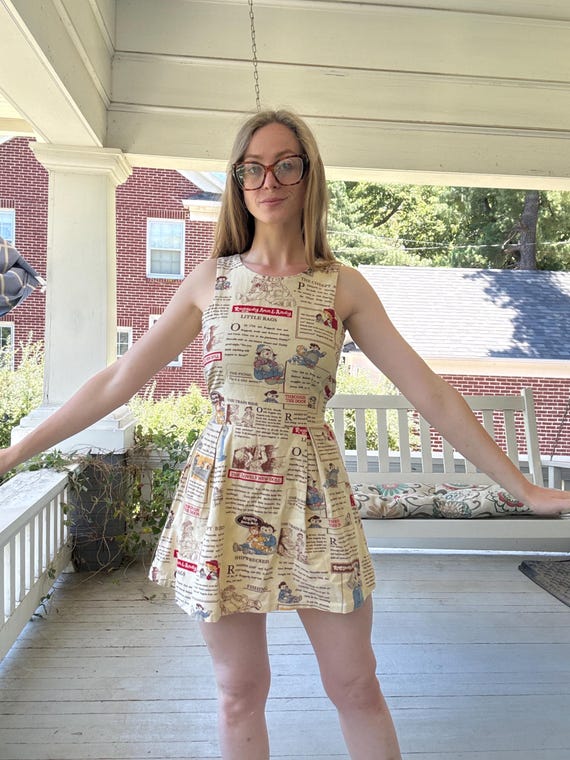 A genuinely handmade mini dress cut from vintage Raggedy Ann novelty print fabric — wearable nostalgia that's one-of-a-kind by definition.