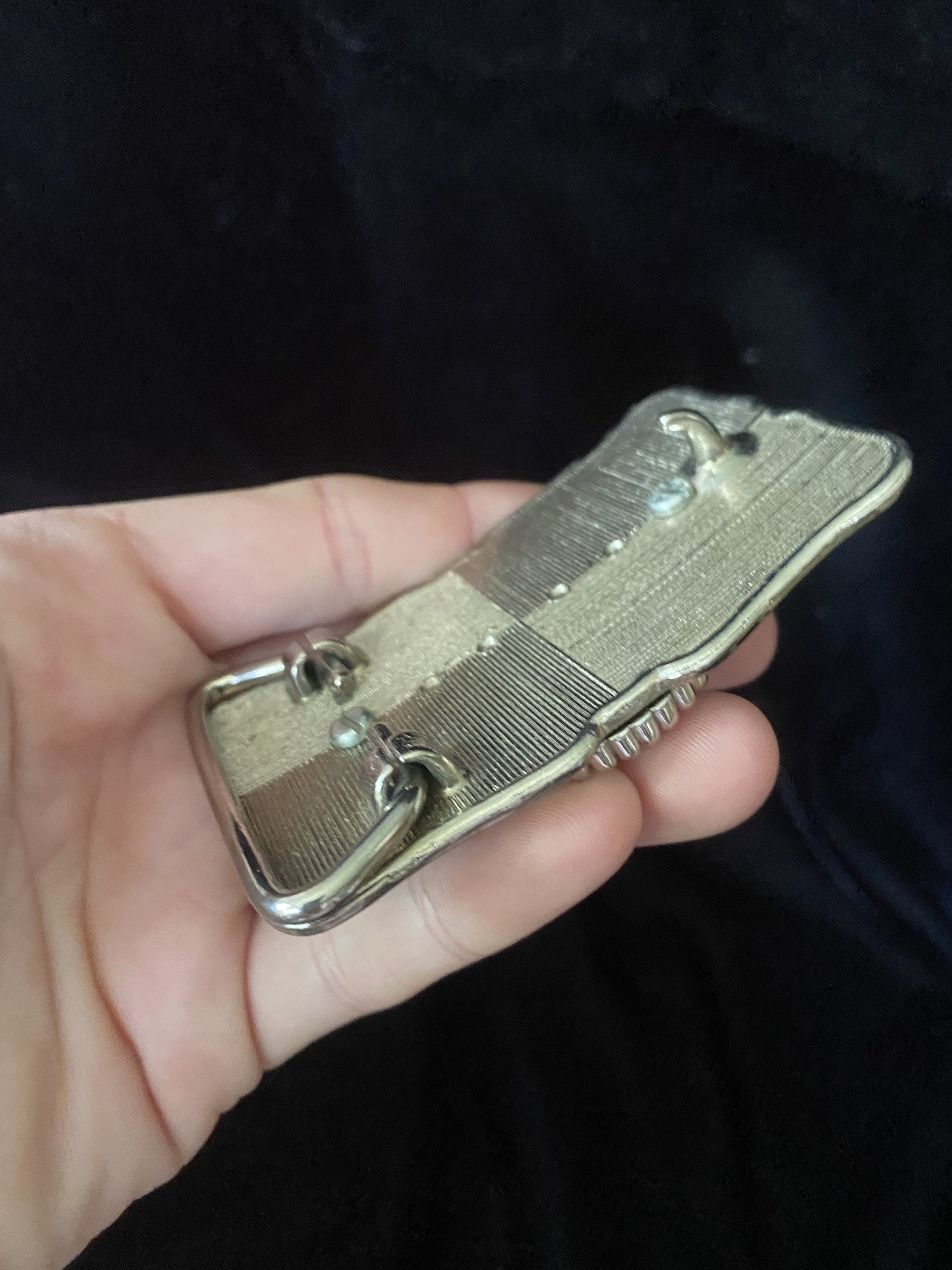 Ceinture en cuir rouge avec une boucle argentée, enroulée sur fond