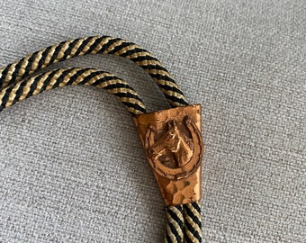Vintage 1980's Black Striped Bolo Tie Witj Copper Colored Pendant With Horse And Horseshoe