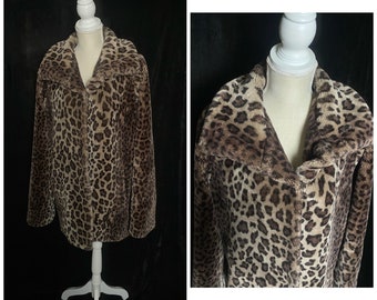May include: A brown and tan leopard print faux fur jacket with a collar. The jacket is on a white mannequin against a black background.