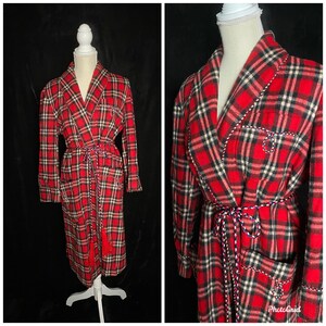 May include: A red and black plaid robe with a long tie belt and tassels. The robe has a shawl collar and two pockets.