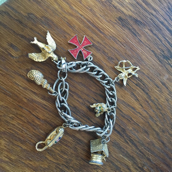 Vintage 1960's gold charm bracelet with a bird, shell, telephone, angel, cross, wishing well, dog, poodle, sea shell