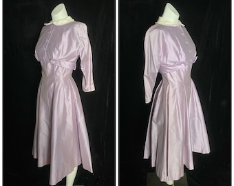 May include: A lavender satin dress with a white collar and long sleeves. The dress has a fitted bodice and a full skirt. It is on a mannequin.