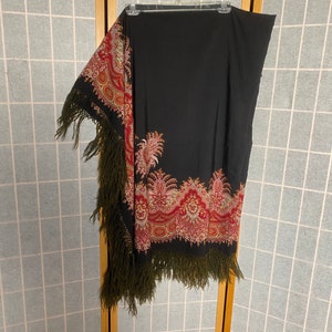 May include: A black shawl with a red, gold, and green paisley pattern and fringe trim.