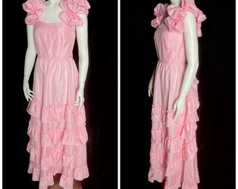 May include: A pink, tiered, sleeveless dress with ruffled sleeves and a gathered waist. The dress is made of a shiny fabric and has a simple, elegant design.