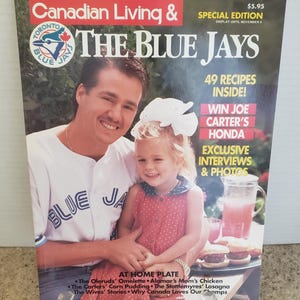 May include: A magazine cover for "Canadian Living & The Blue Jays" featuring a man and a young girl. The cover includes text such as "49 Recipes Inside!" and "Win Joe Carter's Honda". The magazine is a special edition.