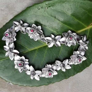 Sleeping Beauty bracelet with 12 roses, 6 rubies and a small frog, rhodium-plated sterling silver,  by Iris Schamberger, fairytale jewellery