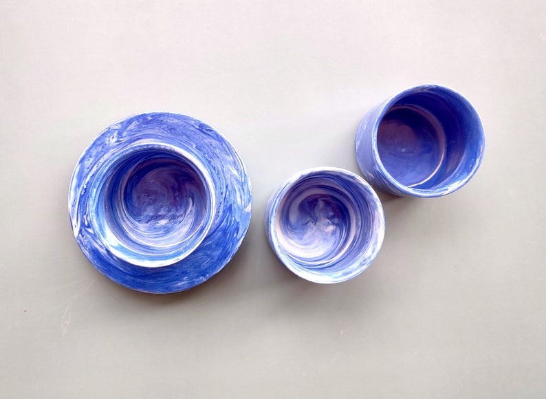 May include: Three blue and white marbled ceramic bowls of different sizes. The bowls have a swirling pattern of blue and white.