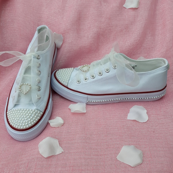 White converse style trainers with pearl detailing.