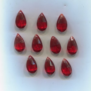 Könnte beinhalten: Zwölf rote tropfenförmige Glasperlen mit einem Loch oben zum Aufziehen.