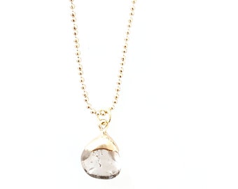 May include: A gold chain necklace with a clear, teardrop-shaped pendant.