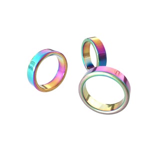 Könnte beinhalten: Drei regenbogenfarbene Ringe in verschiedenen Größen. Die Ringe sind aus Metall und haben eine Regenbogen-Oberfläche.