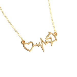 Op de afbeelding: Een gouden ketting met een hart- en hartslaghanger. De hanger is een eenvoudig ontwerp met een hartvorm die is verbonden met een gestileerde hartslaglijn.