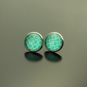 Op de afbeelding: Een paar zilveren oorbel studs met een turquoise en wit geometrisch patroon.