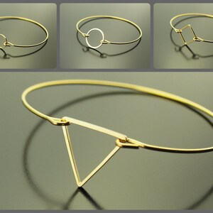 Può includere: Tre braccialetti rigidi in oro con diverse forme geometriche. Il primo braccialetto ha una forma a goccia, il secondo ha un cerchio e il terzo ha un quadrato.
