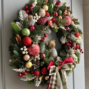 Kerstkrans in groen, goud en rood Elegante deurdecoratie voor de feestdagen