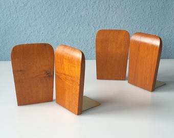 Cuatro sujetalibros de teca con una forma preciosa.