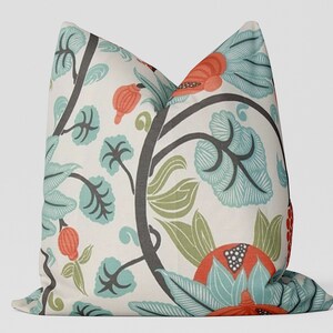 May include: A decorative throw pillow with a floral pattern. The pillow features a white background with a repeating pattern of teal, green, and orange flowers and leaves.