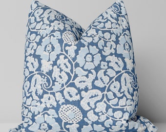 Op de afbeelding: Blauw en wit gepatroneerd kussen met een bloemenmotief.