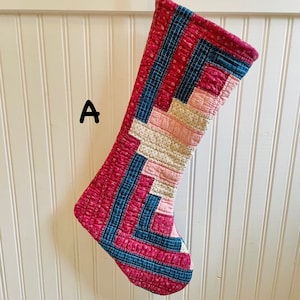 May include: A red, pink, and blue quilted Christmas stocking with a geometric pattern.