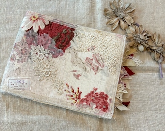 Pode incluir: Uma capa de livro de tecido bege com um padrão floral e guarnição de renda. A capa tem um rótulo que diz "No. 3-9-6 Mtr 11 Yds 12 Coton 100% Made in France."