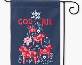Pode incluir: Uma bandeira de jardim de Natal azul com um design escandinavo de cavalo Dala vermelho e branco. A bandeira diz "God Jul" e "Merry Christmas".