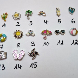 Może przedstawiać: Piętnaście kolorowych emaliowanych zawieszek z różnymi motywami letnimi, w tym kaktus, słońce, palma, tęcza, okulary przeciwsłoneczne, piłka plażowa, koło ratunkowe, klapki i wiatrak.