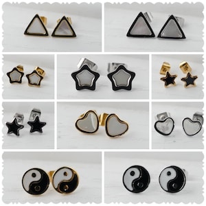 Könnte beinhalten: Ein Set mit 10 Paar Ohrringen in verschiedenen Formen und Designs. Die Ohrringe sind aus Edelstahl und haben eine silberne und goldene Oberfläche. Die Designs umfassen Dreiecke, Sterne, Herzen und Yin-Yang-Symbole.