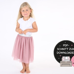Könnte beinhalten: Ein junges Mädchen trägt ein weißes kurzärmeliges Oberteil und einen rosa Tüllrock mit silbernem Bund. Das Bild enthält eine Grafik mit dem Text "PDF-SCHNITT ZUM DOWNLOADEN" und "+ VIDEO ANLEITUNG".
