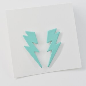 May include: A pair of turquoise lightning bolt shaped earrings.