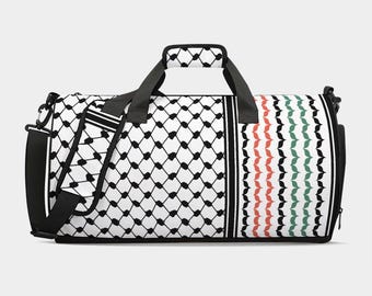 May include: A white and black patterned duffel bag with a black handle and shoulder strap. The bag features a geometric design on one side and a vertical stripe pattern in red, green, and black on the other. The bag is designed for travel or sports.