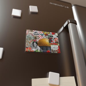 May include: A colorful collage magnet featuring a woman wearing a headscarf, a golden dome building, and Arabic text. The text reads "عالمك" and "الحقوقية".