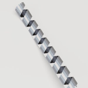 May include: A beaded bracelet with a geometric pattern. The bracelet features a repeating design of gray, black, and white squares. The beads are small and evenly spaced, creating a textured surface. The bracelet is shown against a white background.