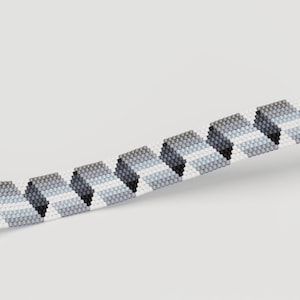 May include: A beaded bracelet with a geometric pattern. The bracelet features a repeating design of gray, black, and white shapes. The beads are small and tightly strung together, creating a textured surface. The bracelet is shown against a white background.